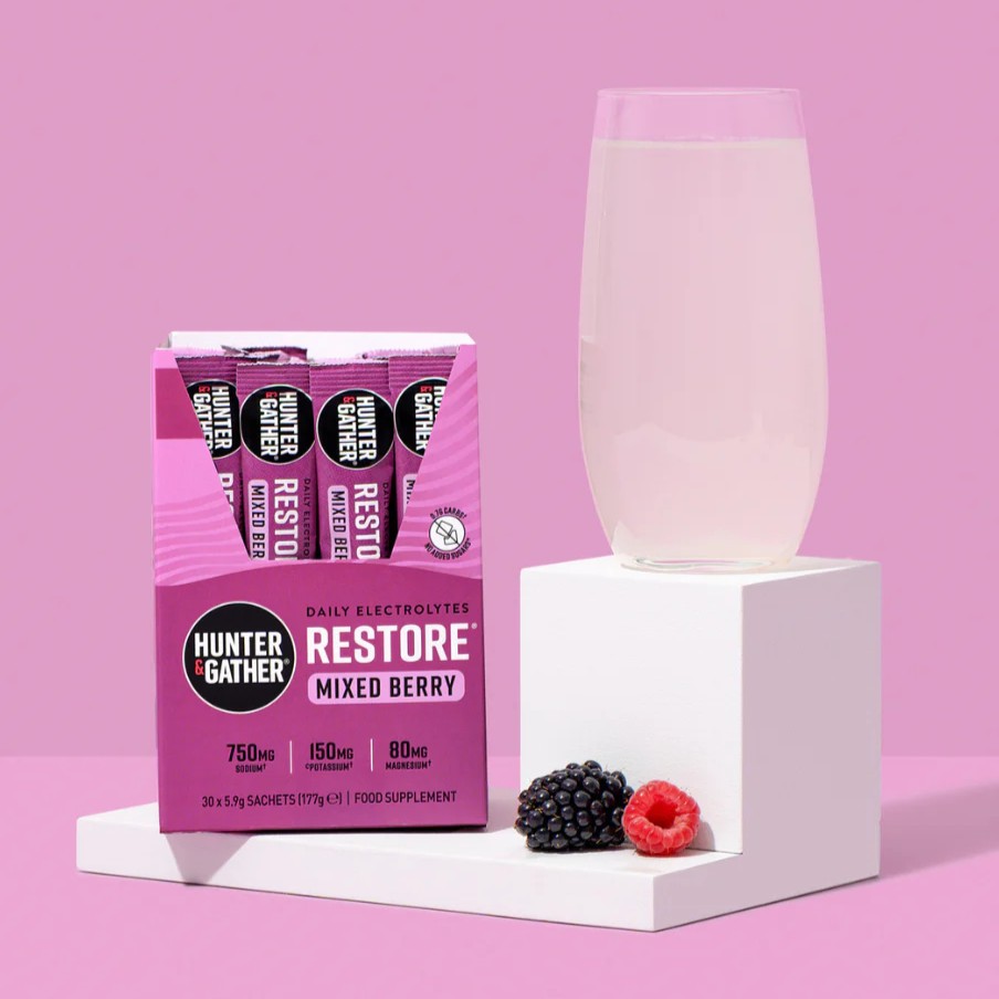Hunter & Gather Restore Mixed Berry sachets with a prepared drink in glass and fresh berries.